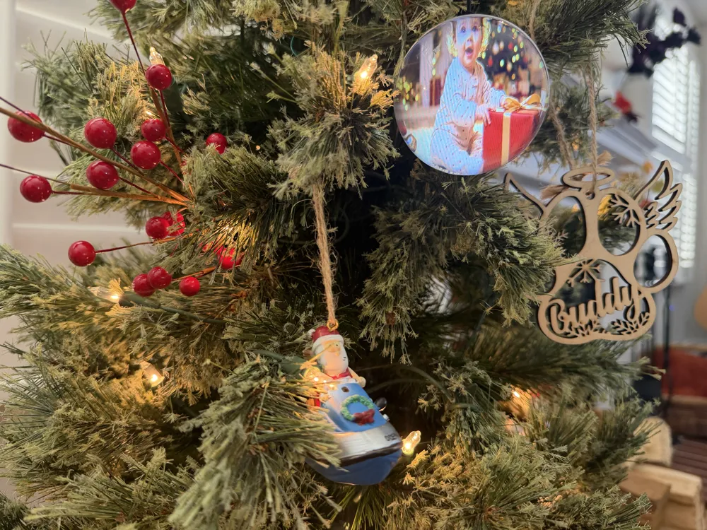 Memory Orb hanging on a real Christmas tree showing a family photo